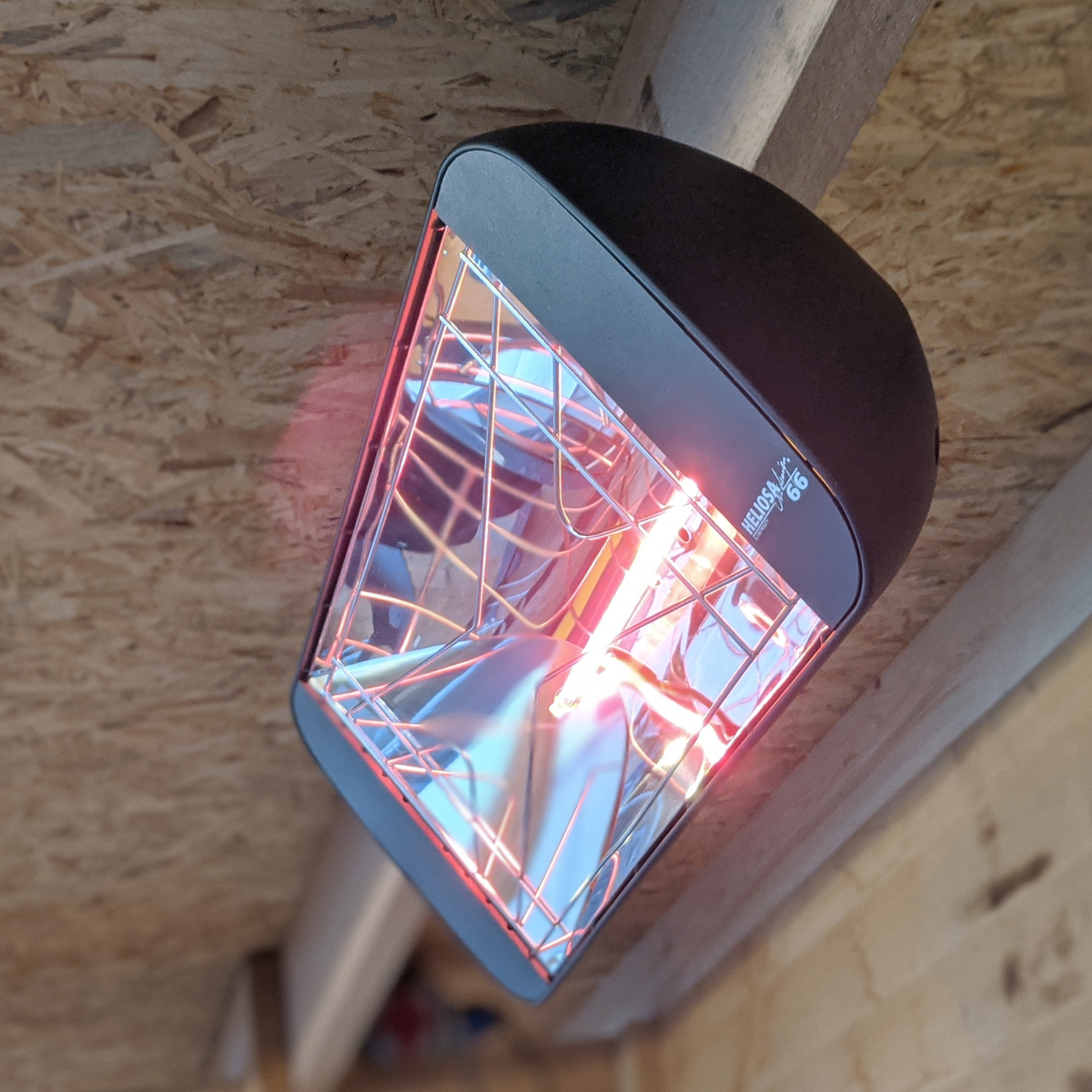 Heliosa 66 Amber Light Infrarot-Heizstrahler in Anthrazit, an der Wand montiert, bietet sofortige Wärme und ist wassergeschützt.