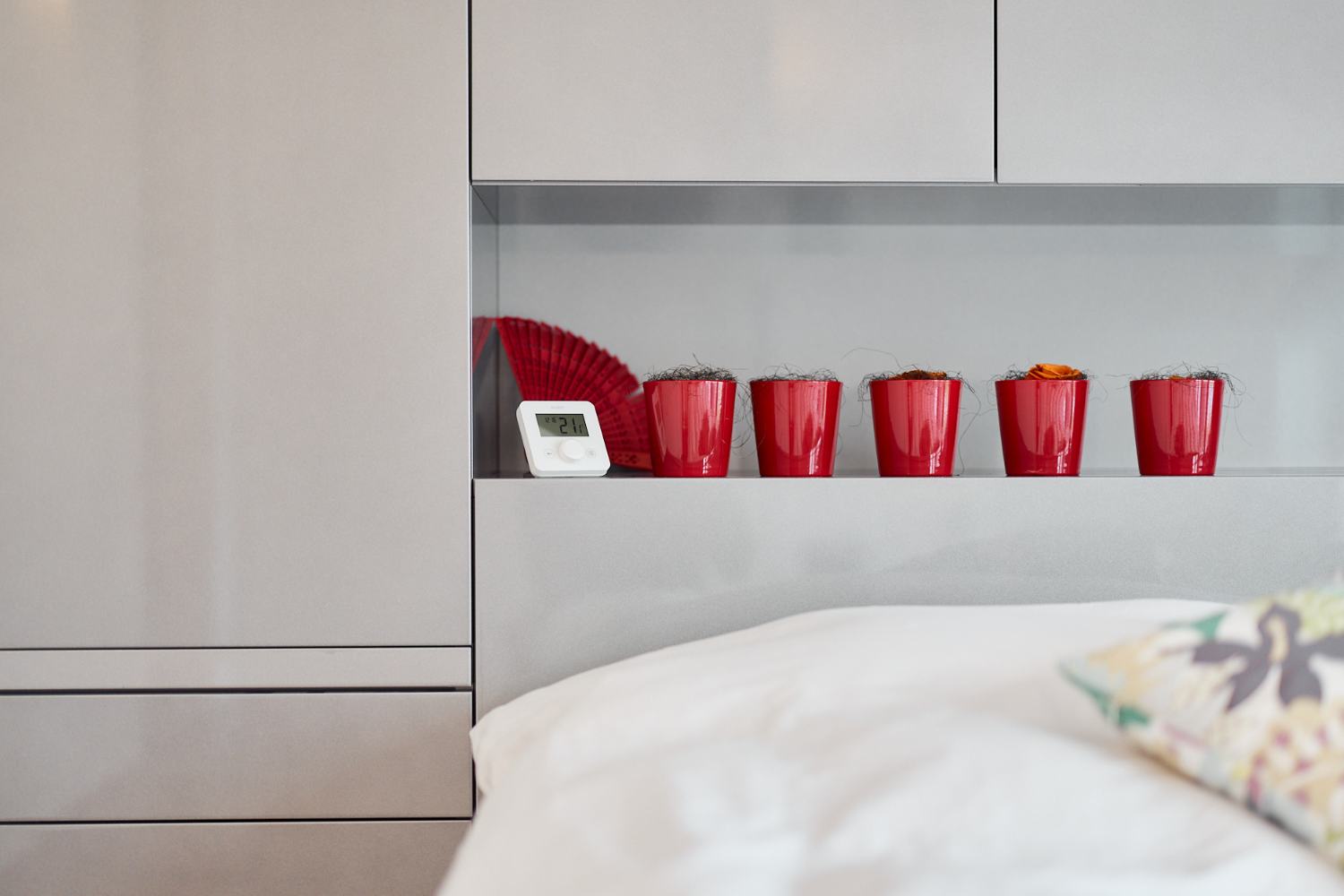 Thermostat ecoheat Sensus sur une étagère derrière un lit
