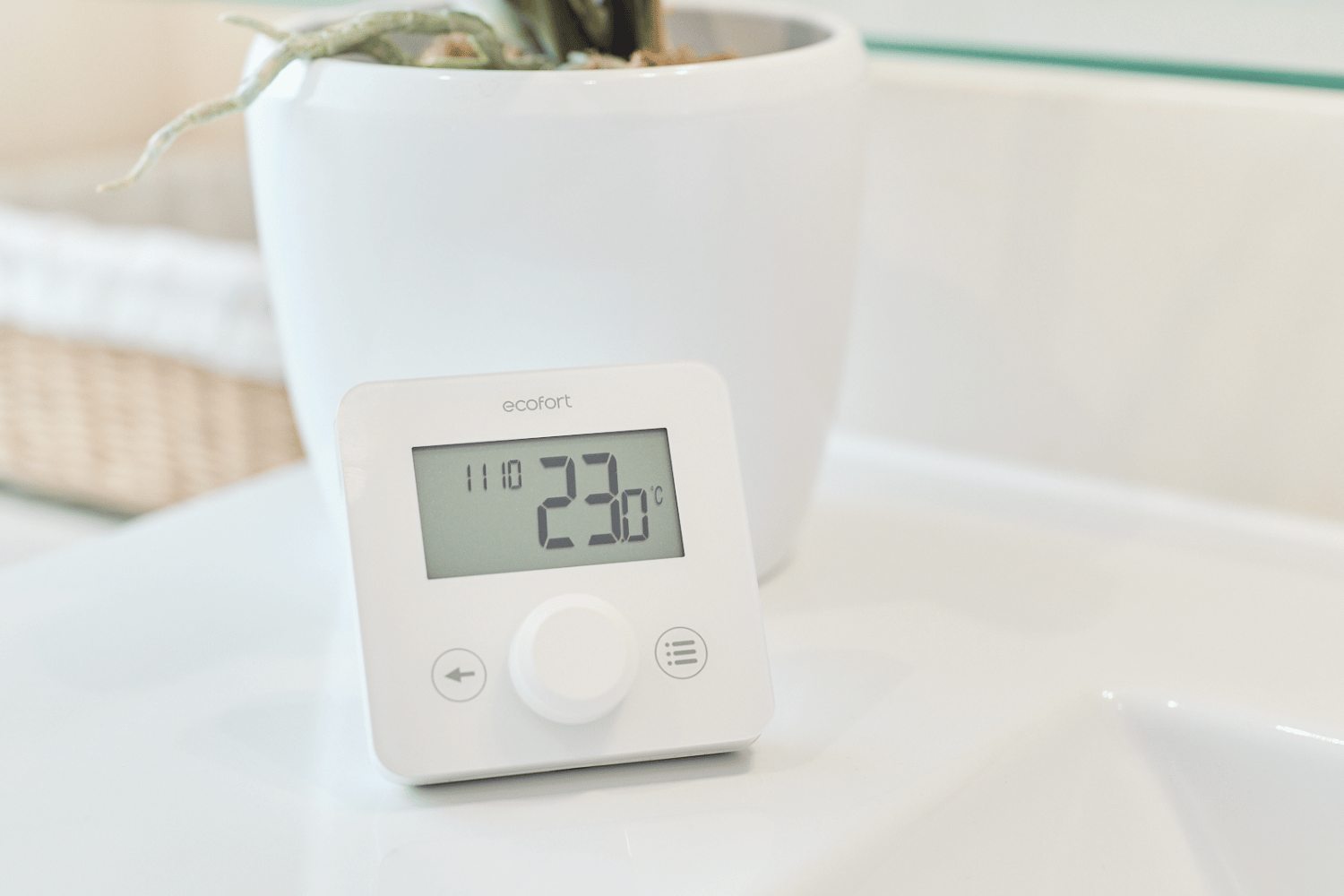 Modernes Thermostat mit digitaler Anzeige und Touch-Bedienung an einer Wand.